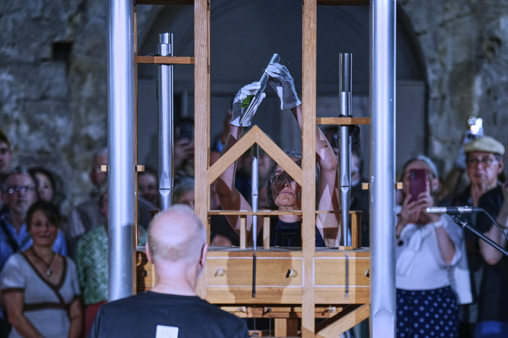 Anneli Borgmann, chairwoman of the John Cage Organ Project adds a pipe during a chord change on the organ inside the medieval Burchardi Church in Halberstadt, Germany, Wednesday, Aug. 5, 2026. (AP Photo/Markus Schreiber)