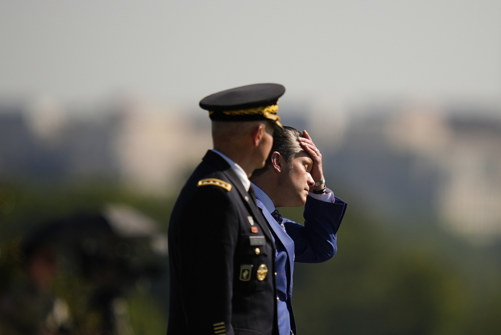 Defense Secretary Pete Hegseth, right, wipes his face while reviewing troops with Army Chief of Staff Gen. Randy George, left, during the POW/MIA National Recognition Day Ceremony at the Pentagon, Friday, Sept. 19, 2025, in Washington. (AP Photo/Julia Demaree Nikhinson)