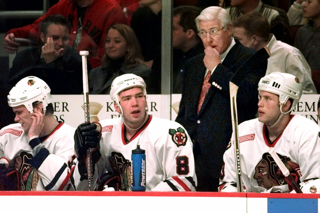 FILE- Bob Pulford, general manager and coach of the Chicago Blackhawks, stands behind players, from left, Jamie Allison, Anders Eriksson and Brad Brown, Dec. 3, 1999, in Chicago, during a game against the Detroit Red Wings. (AP Photo/Ted S. Warren, File)