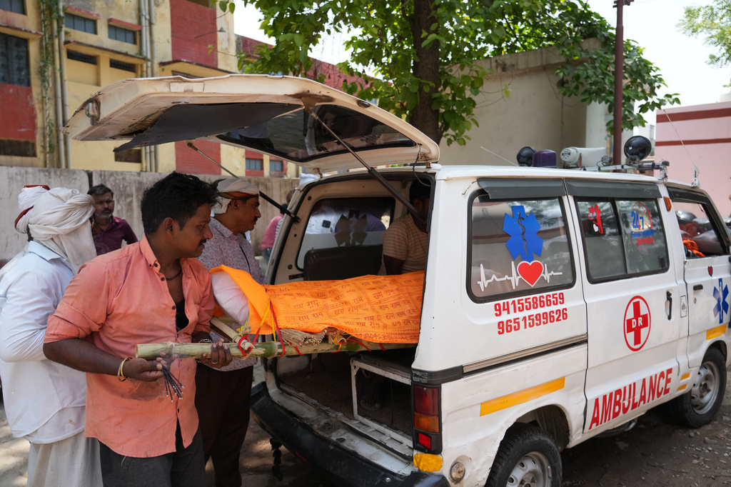 Relatives place the body of Summit Yadav, 24, who died after the wall of his neighbor's house collapsed following dust storms and heavy rain, into an ambulance at a mortuary in Prayagraj, India, Thursday, May 14, 2026. (AP Photo/Rajesh Kumar Singh) CORRECTION: Corrected to that Yadav died after the wall of his neighbor's house collapsed, not his own house's.