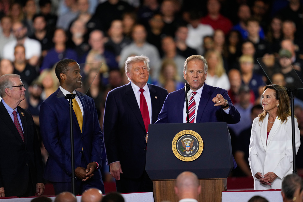 Republican Senate candidate Mike Rogers speaks as Rep. Tim Walberg, R-Mich., Rep. John James, R-Mich., President Donald Trump and Rep. Lisa McClain, R-Mich., listen at an event at the General Motors Proving Ground Monday, July 27, 2026, in Milford, Mich. (AP Photo/Paul Sancya)