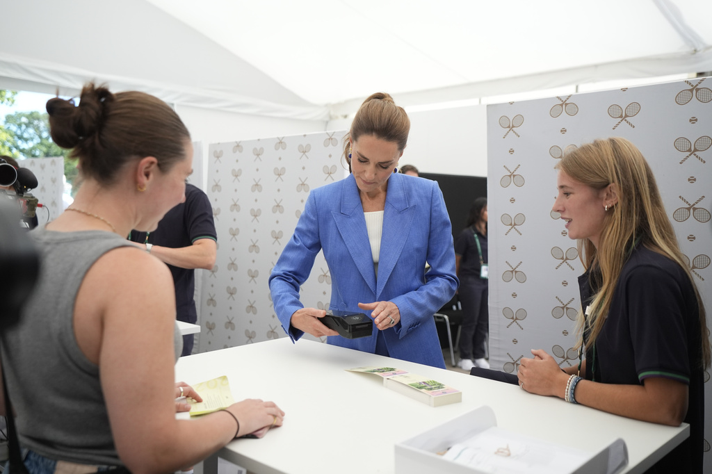 Britain's Kate, the Princess of Wales helps out in the ticket office during a visit on day four of the Wimbledon Tennis Championships in London, Thursday, July 2, 2026. (AP Photo/Andrew Matthews)
