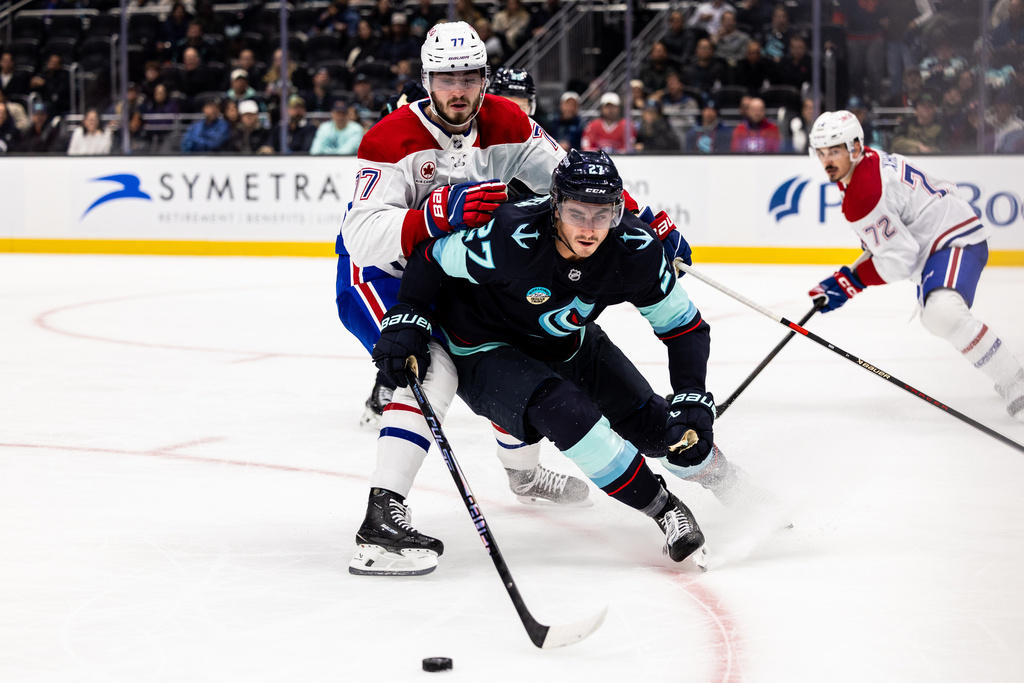 Seattle Kraken left wing Mason Marchment (27) skates in front of Montreal Canadiens center Kirby Dach during the second period of an NHL hockey game Tuesday, Oct. 28, 2025, in Seattle. (AP Photo/Maddy Grassy)