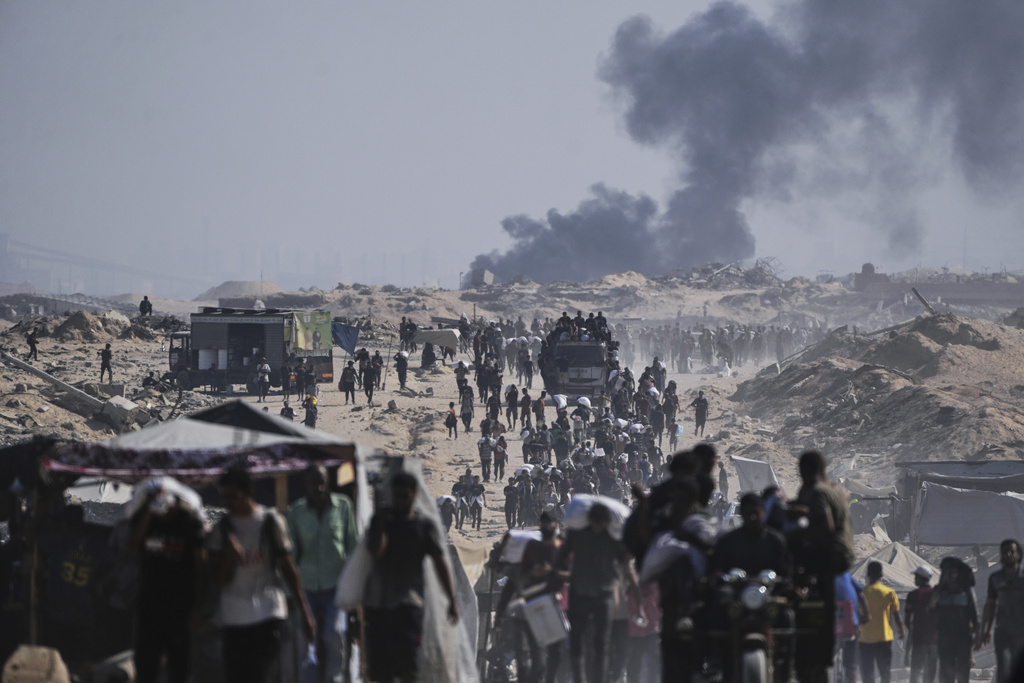 Palestinians carry sacks of flour unloaded from a humanitarian aid convoy on the outskirts of Beit Lahiya, northern Gaza Strip, Saturday, Aug, 23, 2025. (AP Photo/Abdel Kareem Hana)
