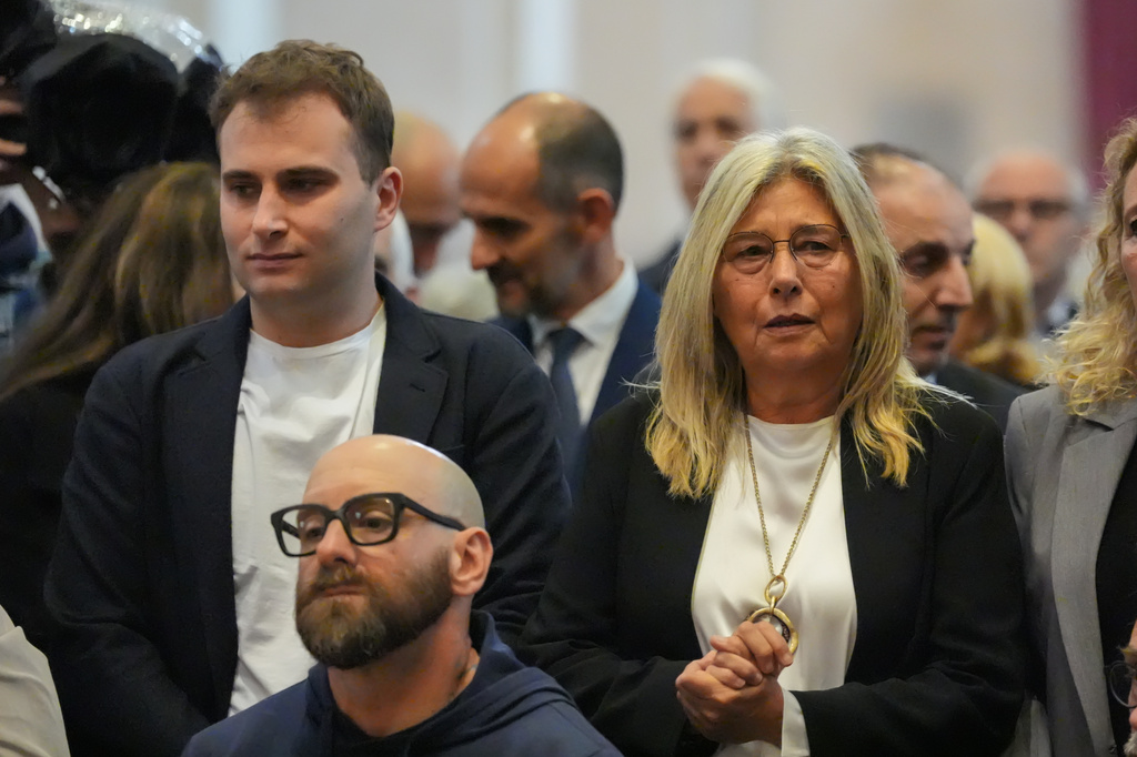 Niccolò Zanardi, son, and Daniela Manni, wife, of Alex Zanardi, Italian auto racing champion-turned-Paralympic gold medalist, attend his funeral inside the Basilica of Santa Giustina, Padua, Italy, Tuesday, May 5, 2026. (Claudio Furlan/LaPresse via AP)