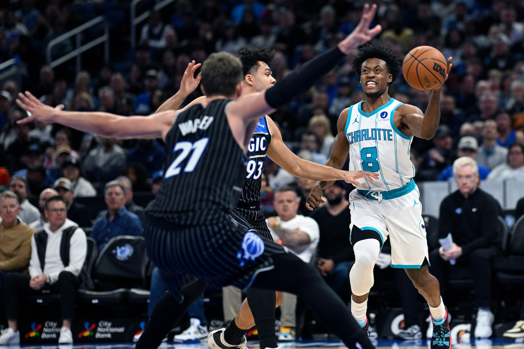 Charlotte Hornets guard Collin Sexton (8) is defended by Orlando Magic forwards Noah Penda (93) and Moritz Wagner (21) during the first half of an NBA basketball game, Thursday, Jan. 22, 2026, in Orlando, Fla. (AP Photo/Phelan M. Ebenhack)