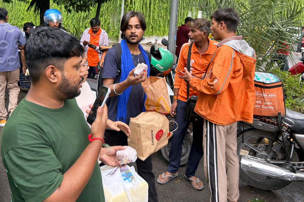 A protestor receives a food package from a supporter at the site where thousands have assembled to join a protest called by Cockroach Janta Party in New Delhi, India, Wednesday, July 22, 2026. (AP Photo/Piyush Nagpal)