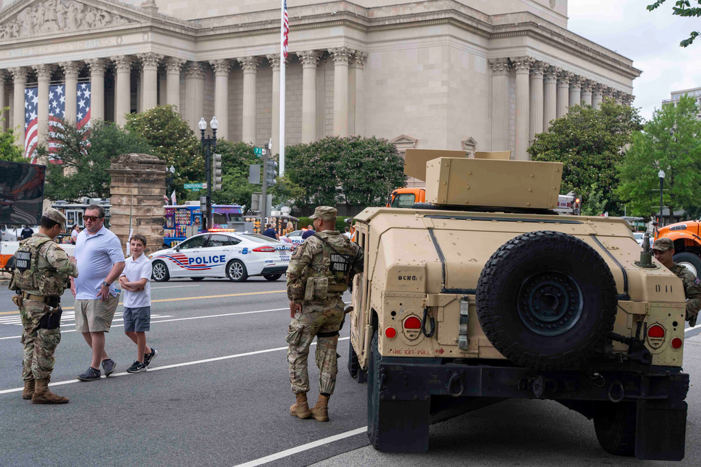 People walk past members of the National Guard stationed outside the Great American State Fair on the National Mall, Saturday June 27, 2026, in Washington. (AP Photo/Jen Golbeck)