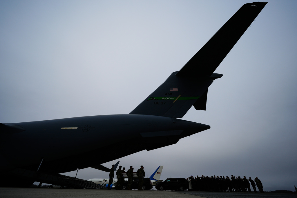 An Army carry team moves a flag-draped transfer case containing the remains of a soldier who was killed in a drone strike at a command center in Kuwait after the U.S. and Israel launched its military campaign against Iran, during a casualty return Saturday, March 7, 2026, at Dover Air Force Base, Del. (AP Photo/Julia Demaree Nikhinson)