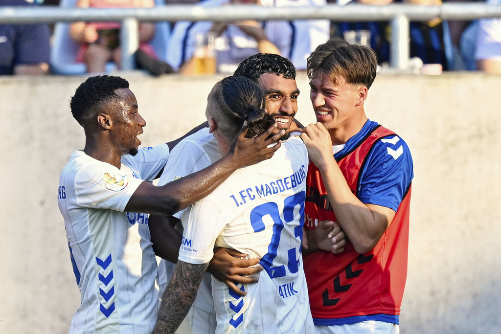 Magdeburg's Rayan Ghrieb, second right, celebrates scoring with teammates during the DFB Cup first round soccer match between FC Saarbrücken and FC Magdeburg at Ludwigspark Stadium in Saarbrücken, Germany, Friday Aug. 15, 2025. (Uwe Anspach/dpa via AP)