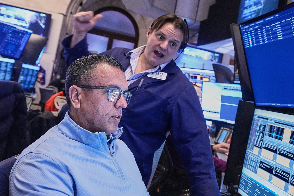 Traders Robert Finnerty Jr., foreground, and Michael Milano work on the floor of the New York Stock Exchange, Monday, Jan. 26, 2026. (AP Photo/Richard Drew)