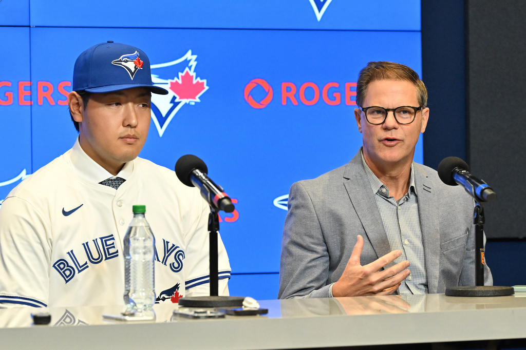 Kazuma Okamoto, left, the Toronto Blue Jays newest signing, sits with team general manager Ross Atkins at an introductory press conference at Rogers Centre in Toronto, Canada, on Tuesday, Jan. 6, 2026. (Jon Blacker/The Canadian Press via AP)