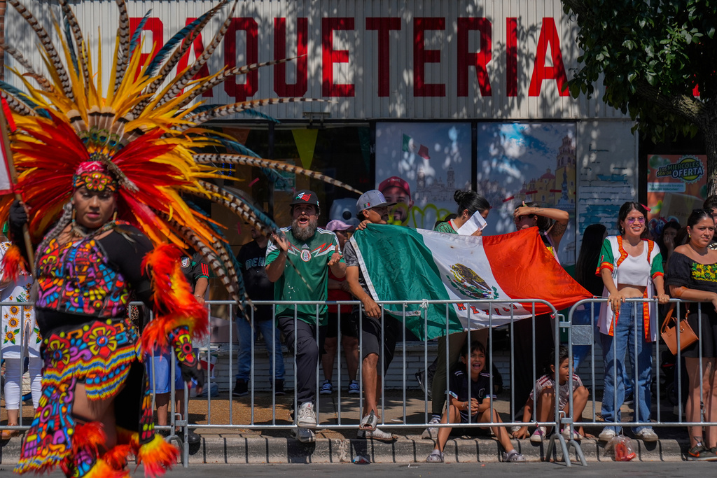 FILE - People watch the Mexican Independence Day Parade, Sept. 14, 2025, in the Little Village neighborhood of Chicago. (AP Photo/Erin Hooley, File)