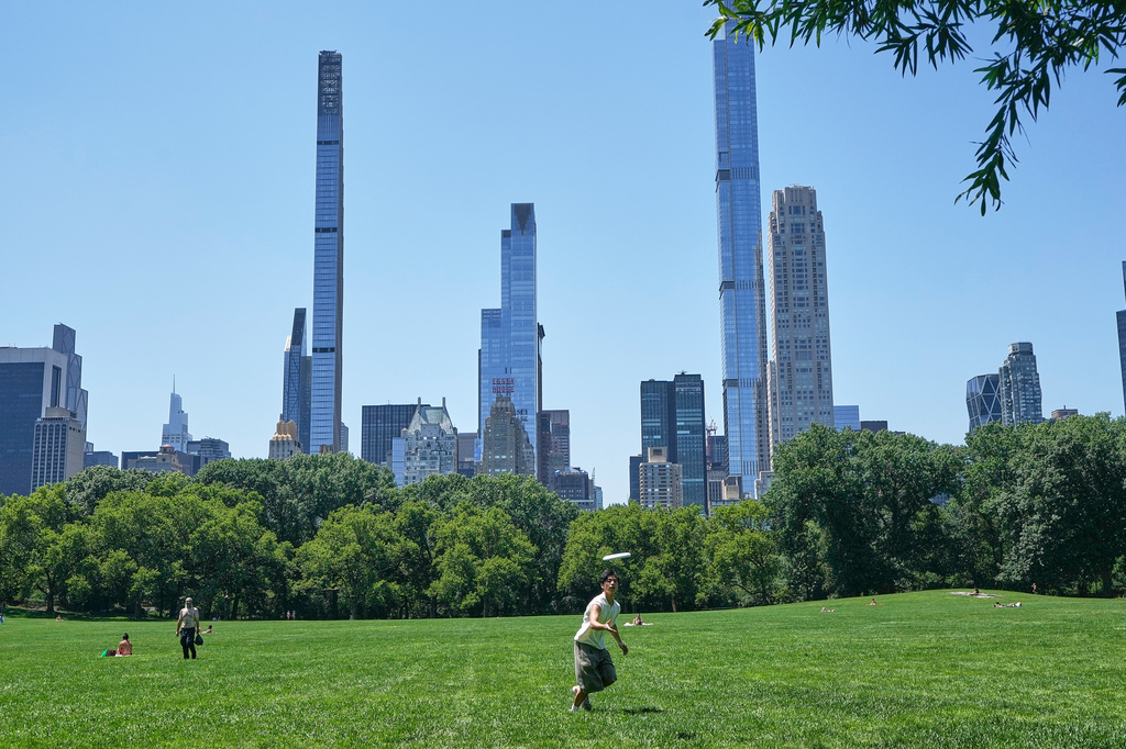 A man plays Frisbee with friends in the Sheep Meadow of New York's Central Park, Thursday, July 2, 2026. (AP Photo/Richard Drew)