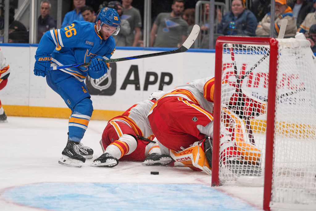 St. Louis Blues' Nathan Walker (26) eyes a loose puck before scoring during the second period of an NHL hockey game against the Calgary Flames Tuesday, Nov. 11, 2025, in St. Louis. (AP Photo/Jeff Roberson)