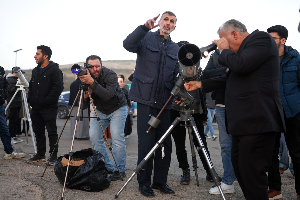 People gather to sight the Ramadan crescent moon marking the beginning of the holy month of Ramadan at the foothills of Mount Qasioun near the Tomb of the Unknown Soldier in Damascus, Tuesday, Feb. 17, 2026. (AP Photo/Ghaith Alsayed)