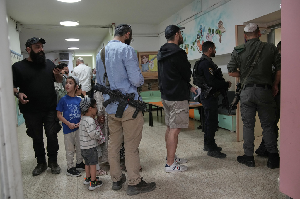 Israeli settlers line up to vote at a school serving as a polling station during Israel's general election in the settlement of Kiryat Arba, in the occupied West Bank, Tuesday, Oct. 27, 2026. (AP Photo/Leo Correa)