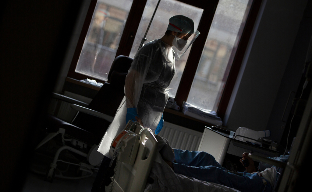 FILE - A medic from the Belgian Army tends to a patient with COVID-19 at the St. Michiel Hospital in Brussels, Tuesday, Nov. 24, 2020. (AP Photo/Virginia Mayo, File)