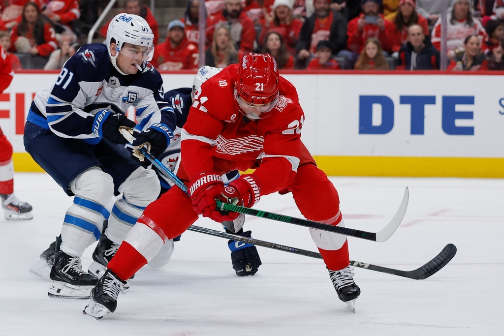 Winnipeg Jets center Cole Perfetti (91) ties up Detroit Red Wings left wing James van Riemsdyk (21) during the second period of an NHL hockey game, Wednesday, Dec. 31, 2025, in Detroit. (AP Photo/Duane Burleson)