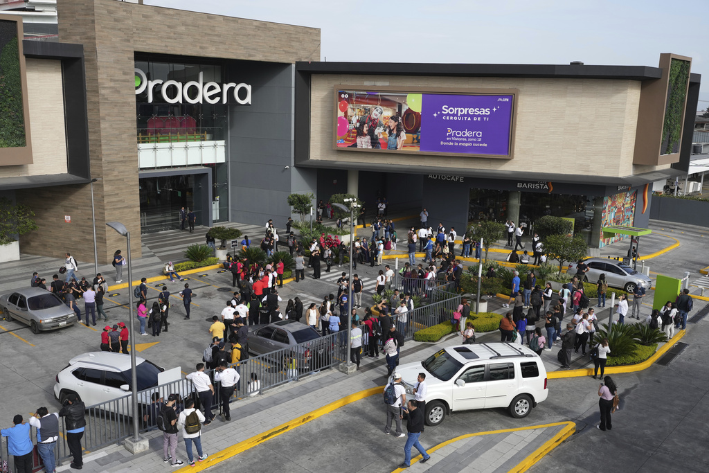 People gather outside of a shopping mall after an earthquake in Guatemala City, Tuesday, July 8, 2025. (AP Photo/Moises Castillo)