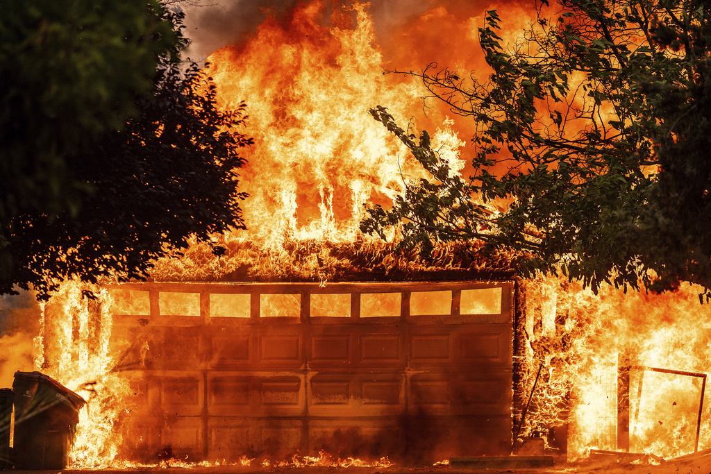 Flames consume a garage as the 6-5 Fire burns through the Chinese Camp community of Tuolumne County, Calif., on Tuesday, Sept. 2, 2025. (AP Photo/Noah Berger)