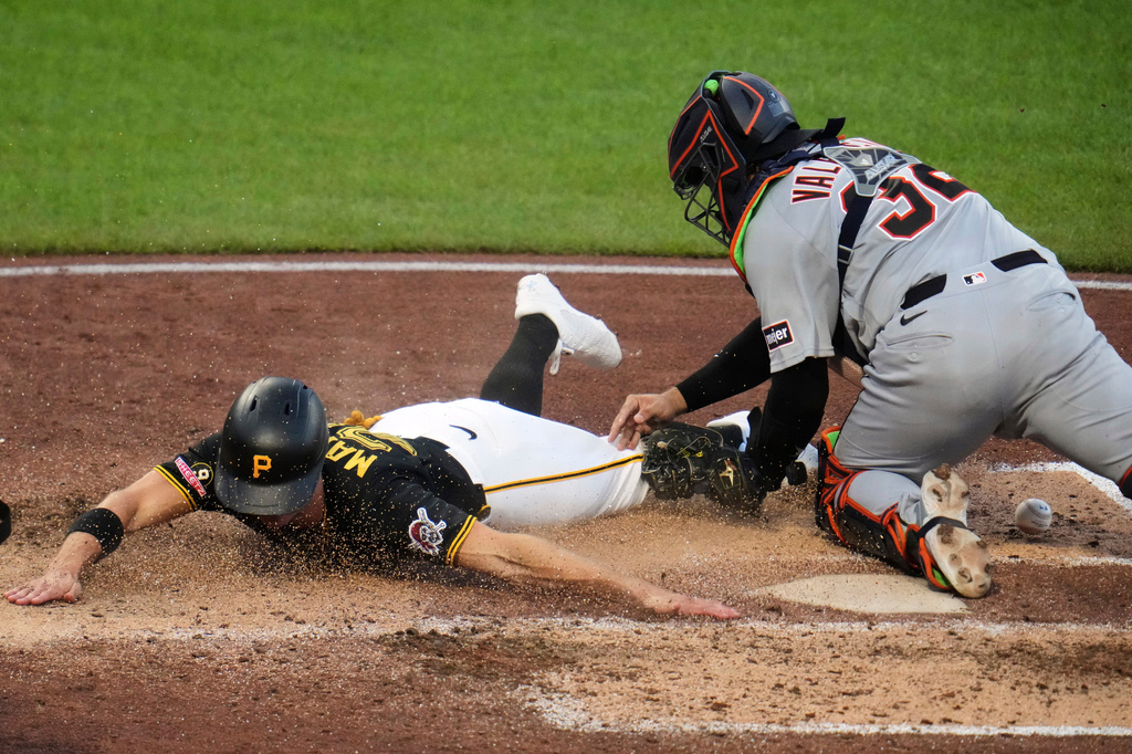 Pittsburgh Pirates' Jake Mangum, left, is ruled out when he can't reach home plate as he slides around Detroit Tigers catcher Eduardo Valencia, who drops the ball on the play, during the fifth inning of a baseball game in Pittsburgh, Tuesday, Aug. 18, 2026. (AP Photo/Gene J. Puskar)