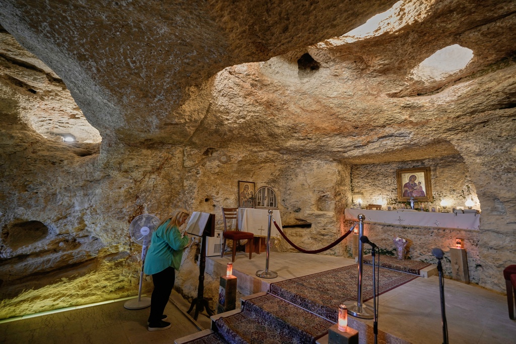 A woman prays inside the cave shrine of Our Lady of Waiting, Saydet al-Mantra, which local tradition identifies as the place where Mary waited for Jesus as he traveled through the nearby cities of Sidon and Tyre, where he answered a mother's plea to heal her daughter, at the southern village of Maghdouche, Lebanon, Sunday, Nov. 16, 2025. (AP Photo/Hassan Ammar)