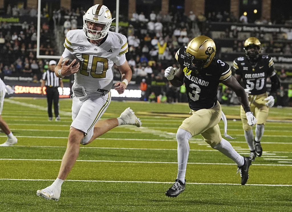 Georgia Tech quarterback Haynes King, left, runs past Colorado cornerback Teon Parks (3) for a touchdown in the second half of an NCAA college football game Friday, Aug. 29, 2025, in Boulder, Colo. (AP Photo/David Zalubowski)