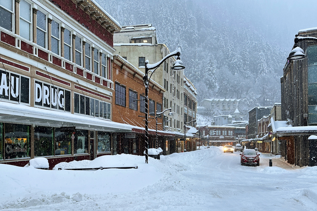 A car drives down a snowy main street in downtown Juneau, Alaska, Monday, Dec. 29, 2025. (AP Photo/Becky Bohrer)