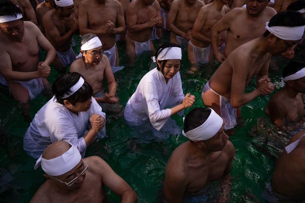 Participants bathe in ice-cold water to purify their souls and pray for good health during a New Year's ritual at Teppozu Inari Shrine in Tokyo, Sunday, Jan. 11, 2026. (AP Photo/Louise Delmotte)
