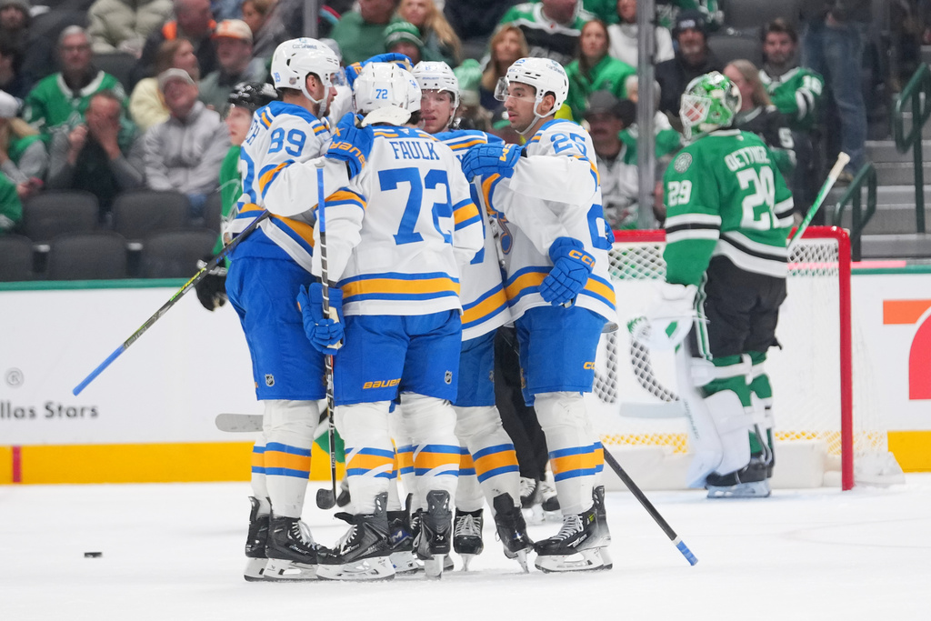 St. Louis Blues players celebrate a first period power play goal by right wing Jordan Kyrou, center right, as Dallas Stars goaltender Jake Oettinger, far right, looks on during an NHL hockey game Friday, Jan. 23, 2026, in Dallas. (AP Photo/Julio Cortez)