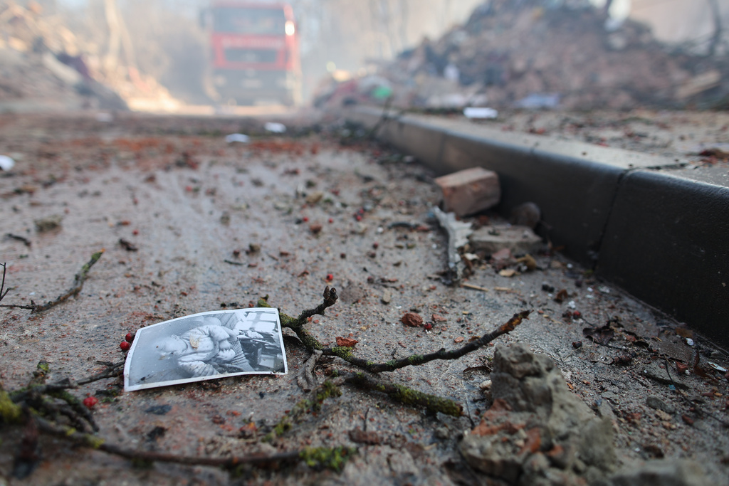 A photograph of a child lies on the ground near a residential building which was heavily damaged by a Russian strike on Ternopil, Ukraine, on Wednesday, Nov. 19, 2025. (AP Photo/Vlad Kravchuk)