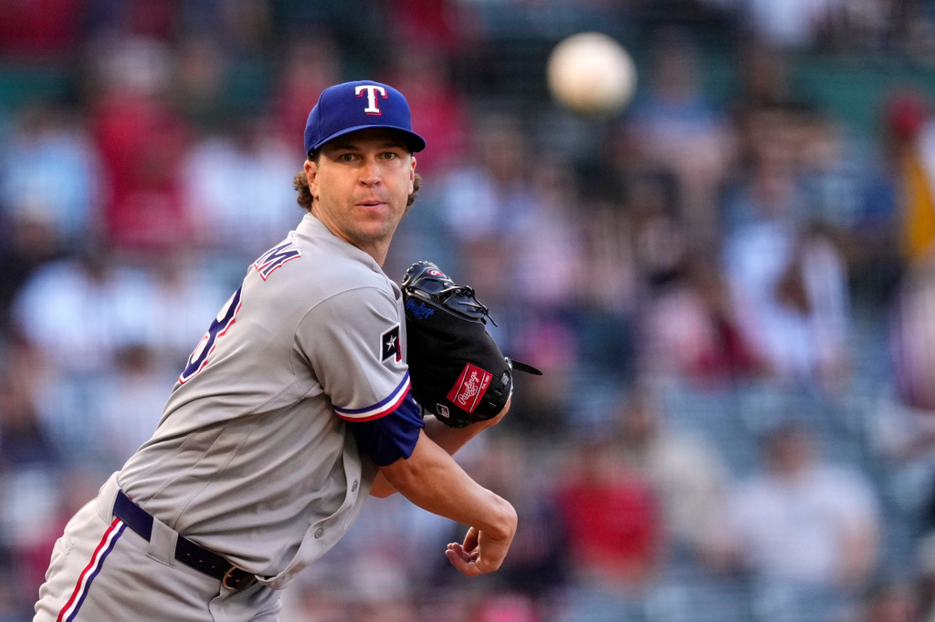 Texas Rangers pitcher Jacob Degrom throws to first in an attempt to get Los Angeles Angels' Mike Trout off base during the first inning of a baseball game against the Los Angeles Angels, Friday, May 22, 2026, in Anaheim, Calif. (AP Photo/Mark J. Terrill)