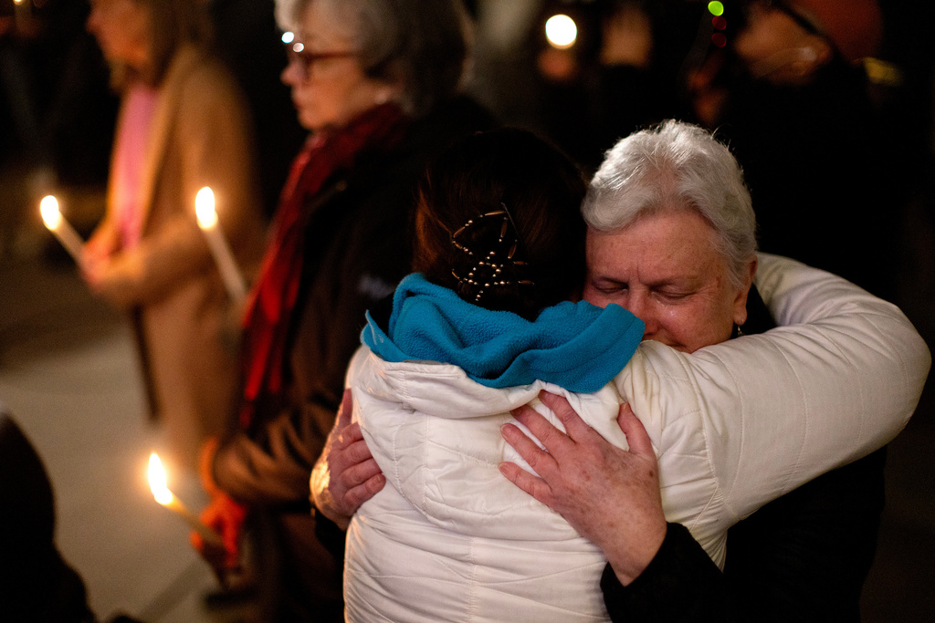 People console one another during a candle light vigil at the front steps of the legislature in Victoria, B.C., on Wednesday, Feb. 11, 2026 in honor of the victims of the school shooting in Tumbler Ridge, B.C. (Chad Hipolito/The Canadian Press via AP)