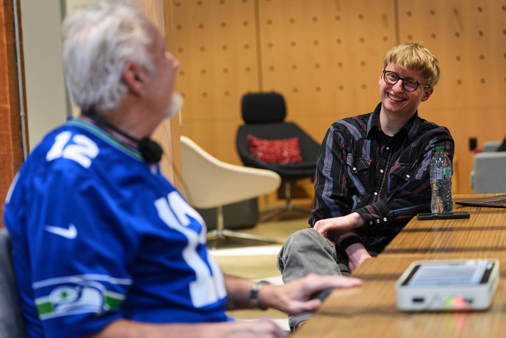 OneCourt founder Jerred Mace, right, talks with Clark Roberts, a blind Seattle Seahawks fan who has had the chance to try out OneCourt tablet, a tactile device that vibrates on key plays and provides real-time audio of games, at the T-Mobile Innovation Hub Tuesday, Jan. 27, 2026, in Bellevue, Wash. (AP Photo/Lindsey Wasson)
