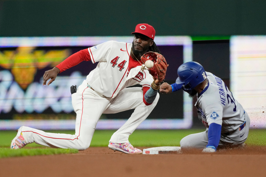 Cincinnati Reds shortstop Elly De La Cruz (44), takes the throw as Los Angeles Dodgers' Teoscar Hernández (37) steals second base during the seventh inning of a baseball game, Monday, Sept. 14, 2026, in Cincinnati. (AP Photo/Carolyn Kaster)