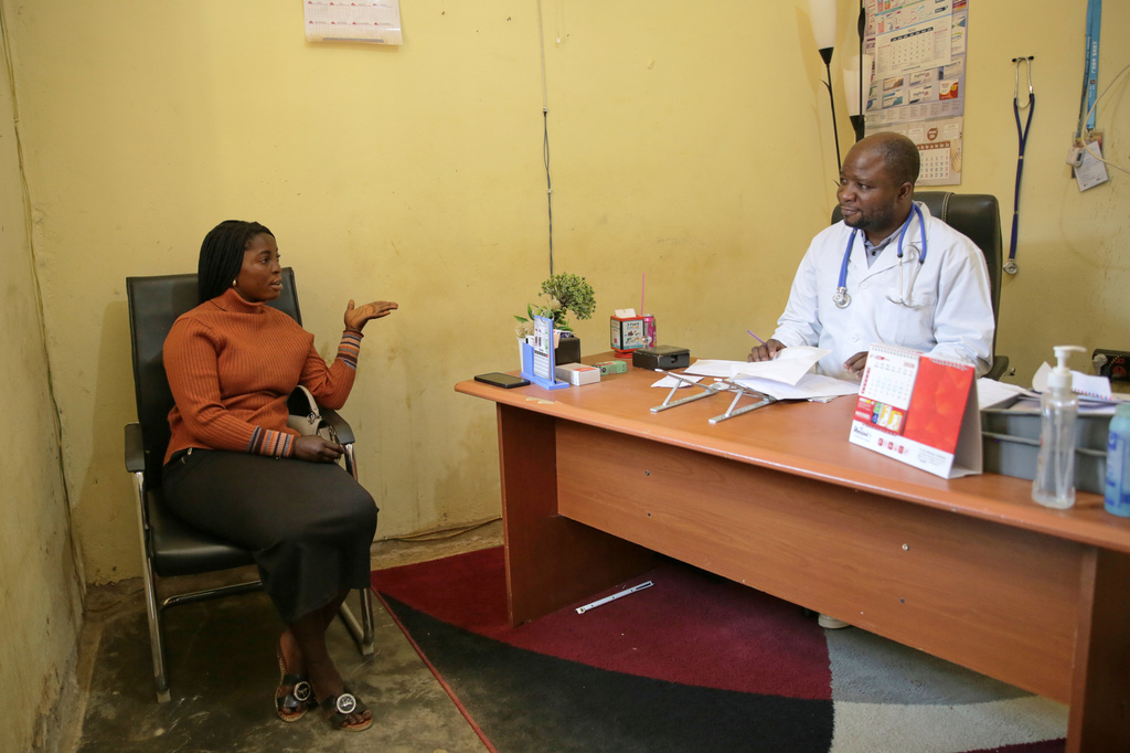 Dr. Babah Mutuza Lusungu, right, a doctor at "Dieu Est Grand" Medical Center, attends to a woman in his office in Beni, Congo, Monday, June 1, 2026. (AP Photo/Kitsa Musayi Sebastien)
