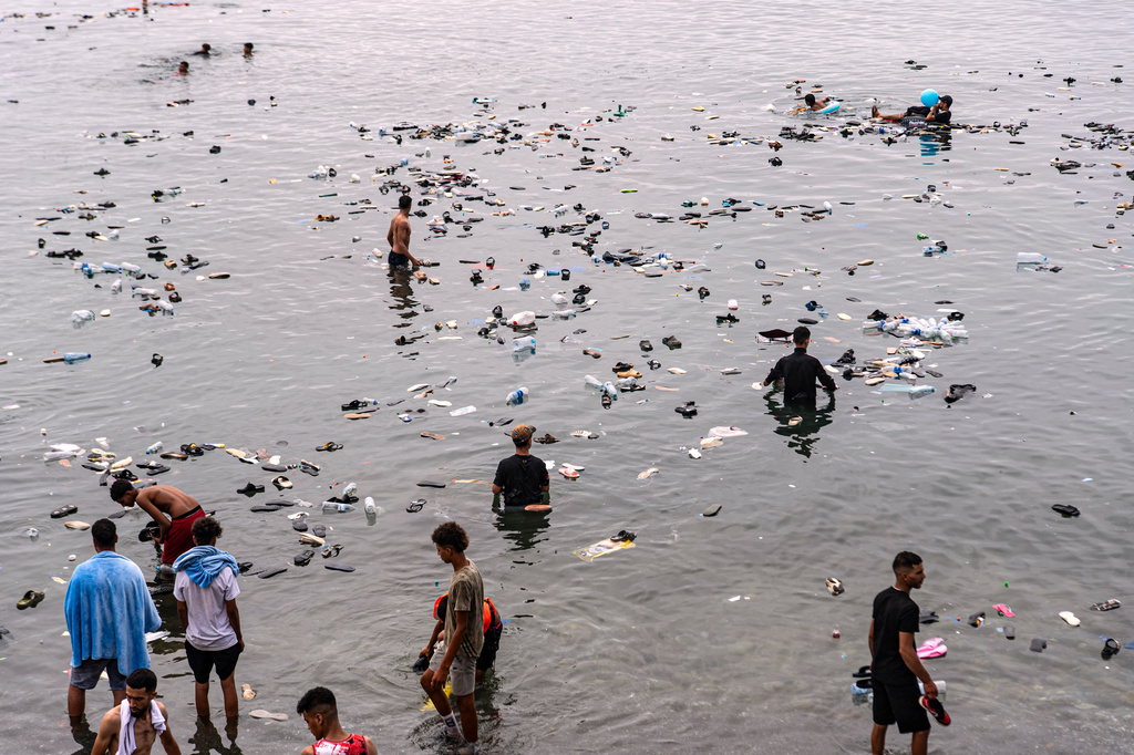 Belongings left behind by migrants float in the sea after they crossed from Morocco into the Spanish enclave of Ceuta, Friday, July 31, 2026. (AP Photo/Antonio Sempere)