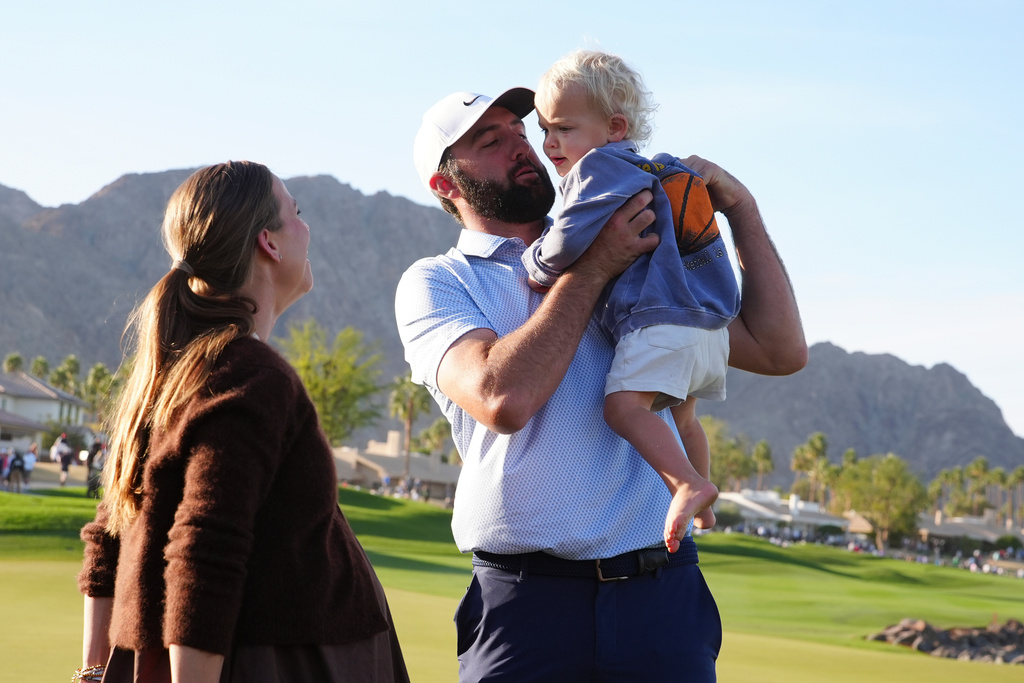 After winning the American Express golf event, Scottie Scheffler, center, celebrates with son Bennett, right, and wife Meredith Scudder-Scheffler, left, on the Pete Dye Stadium Course at PGA West Sunday, Jan. 25, 2026, in La Quinta, Calif. (AP Photo/Ross D. Franklin)