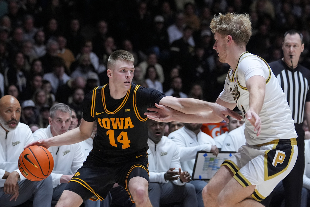 Iowa guard Bennett Stirtz (14) holds off Purdue guard Jack Benter (14) during the first half of an NCAA college basketball game in West Lafayette, Ind., Wednesday, Jan. 14, 2026. (AP Photo/Michael Conroy)