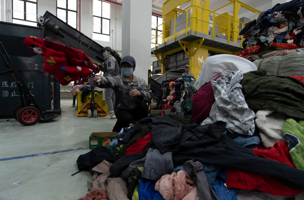A worker labors at a textile sorting facility that employ's Databeyond's Fastsort-Textile AI sorting machine in Zhangjiagang in eastern China's Jiangsu province on March 20, 2026. (AP Photo/Ng Han Guan)