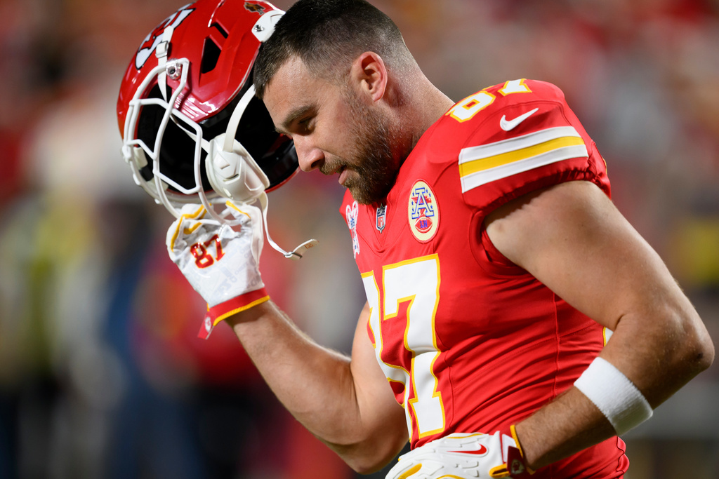 FILE - Kansas City Chiefs tight end Travis Kelce takes off his helmet during warmups before an NFL football game against the Denver Broncos, Dec. 25, 2025, in Kansas City, Mo. (AP Photo/Reed Hoffmann, File)