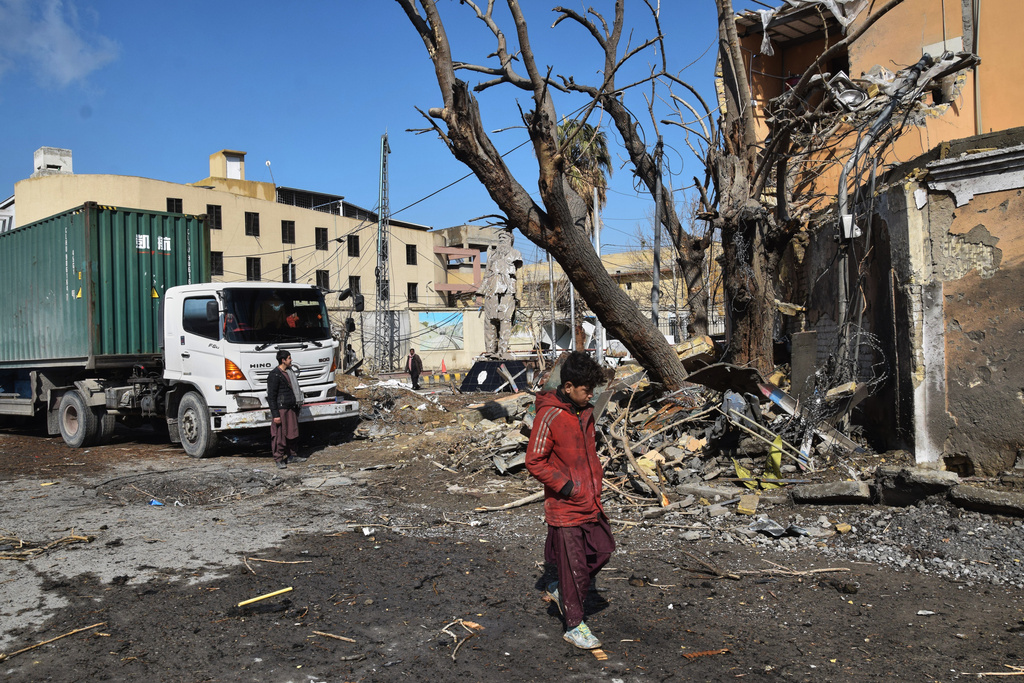 People walk past the site of Saturday's suicide bombing, in Quetta, Pakistan, Sunday, Feb. 1, 2026. (AP Photo/Arshad Butt)