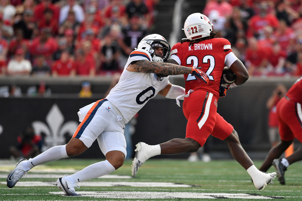 Virginia safety Antonio Clary (0) grabs Louisville Cardinals running back Keyjuan Brown (22) during the second half of an NCAA college football game in Louisville, Ky., Saturday, Oct. 4, 2025. (AP Photo/Timothy D. Easley)