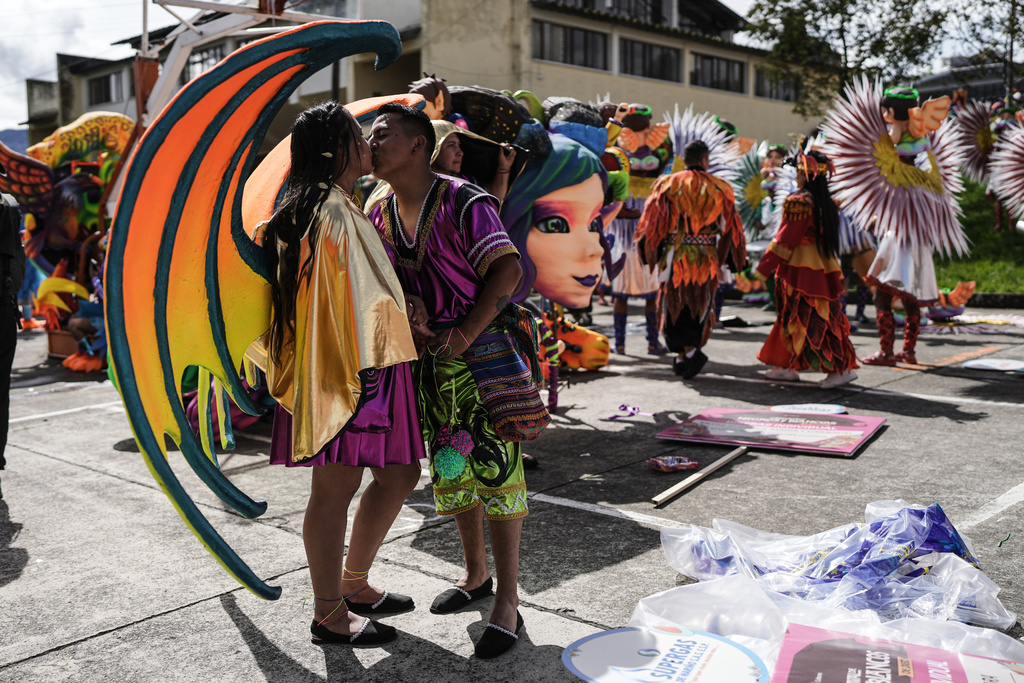 Revelers kiss prior to the start of the Black and White Carnival, recognized by UNESCO as Intangible Cultural Heritage, in Pasto, Colombia, Tuesday, Jan. 6, 2026. (AP Photo/Ivan Valencia)
