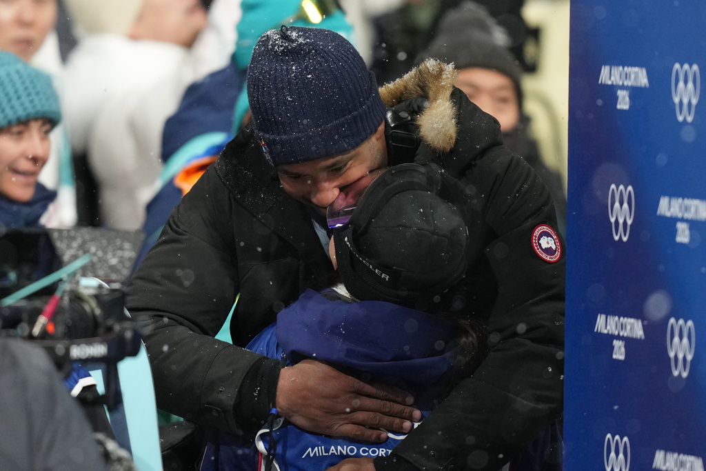 Cleveland Browns' Myles Garrett and United States' Chloe Kim kiss after Kim won the silver medal in the women's snowboarding halfpipe finals at the 2026 Winter Olympics, in Livigno, Italy, Thursday, Feb. 12, 2026. (AP Photo/Abbie Parr)