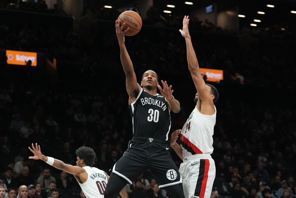 Brooklyn Nets' Ochai Agbaji (30) shoots over Portland Trail Blazers' Kris Murray (24) and Scoot Henderson (00) during the first half of an NBA basketball game Monday, March 16, 2026, in New York. (AP Photo/Frank Franklin II)