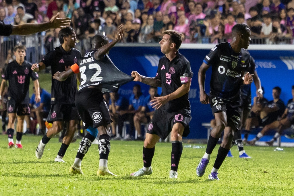 Inter Miami's Lionel Messi grabs the jersey of Jhegson Méndez of Ecuador's Independiente del Valle during an international friendly soccer match in Bayamon, Puerto Rico, Thursday, Feb. 26, 2026. (AP Photo/Alejandro Granadillo)