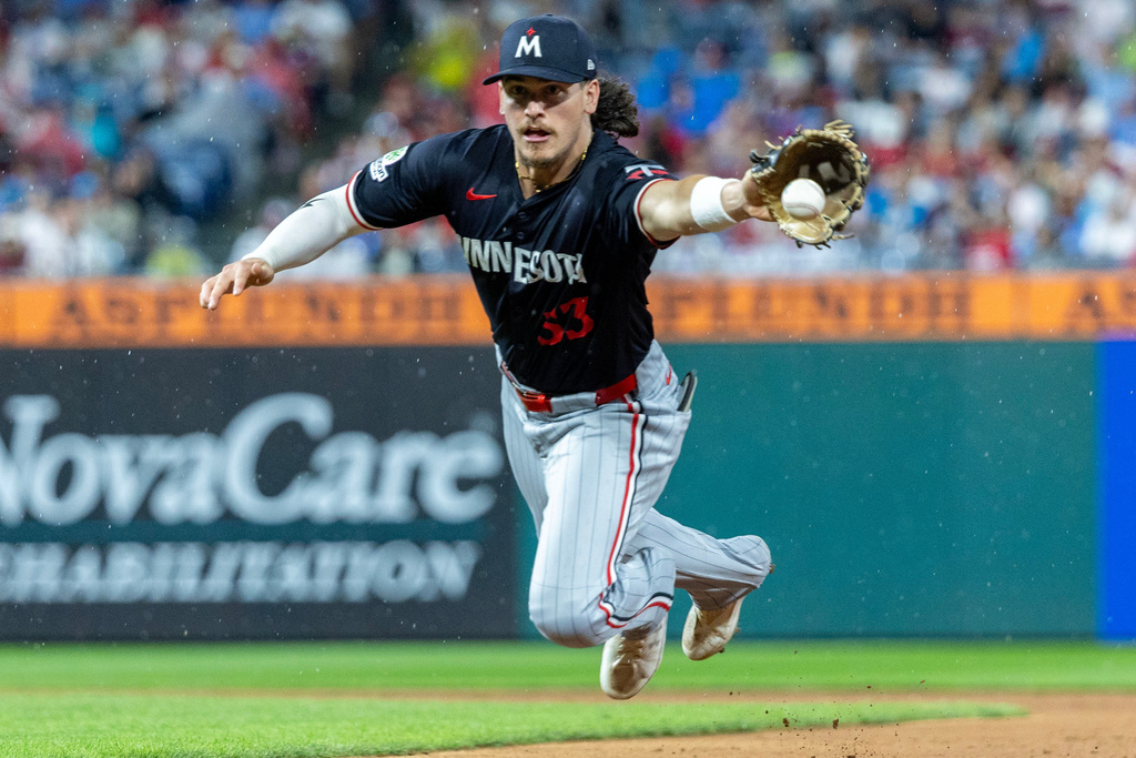 Minnesota Twins second baseman Ryan Fitzgerald leaps for a single from Philadelphia Phillies' Bryson Stott during the fifth inning of a baseball game, Saturday, Sept. 27, 2025, in Philadelphia. (AP Photo/Laurence Kesterson)