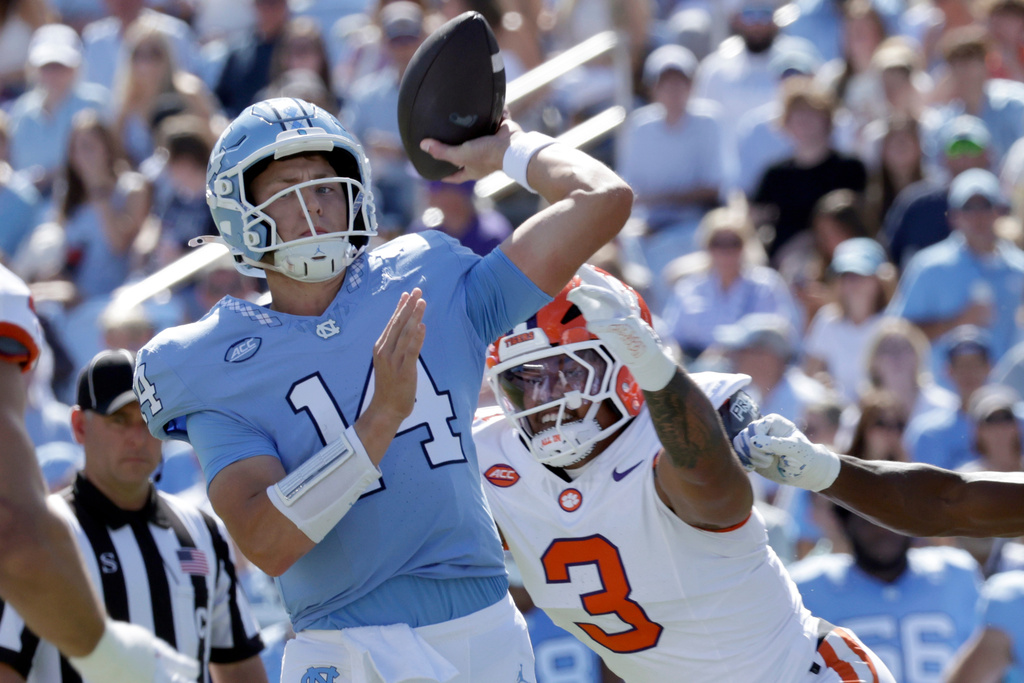 North Carolina quarterback Max Johnson (14) throws as pass as he is pressured by Clemson defensive end T.J. Parker (3) during the first half of an NCAA college football game Saturday, Oct. 4, 2025, in Chapel Hill, N.C. (AP Photo/Chris Seward)
